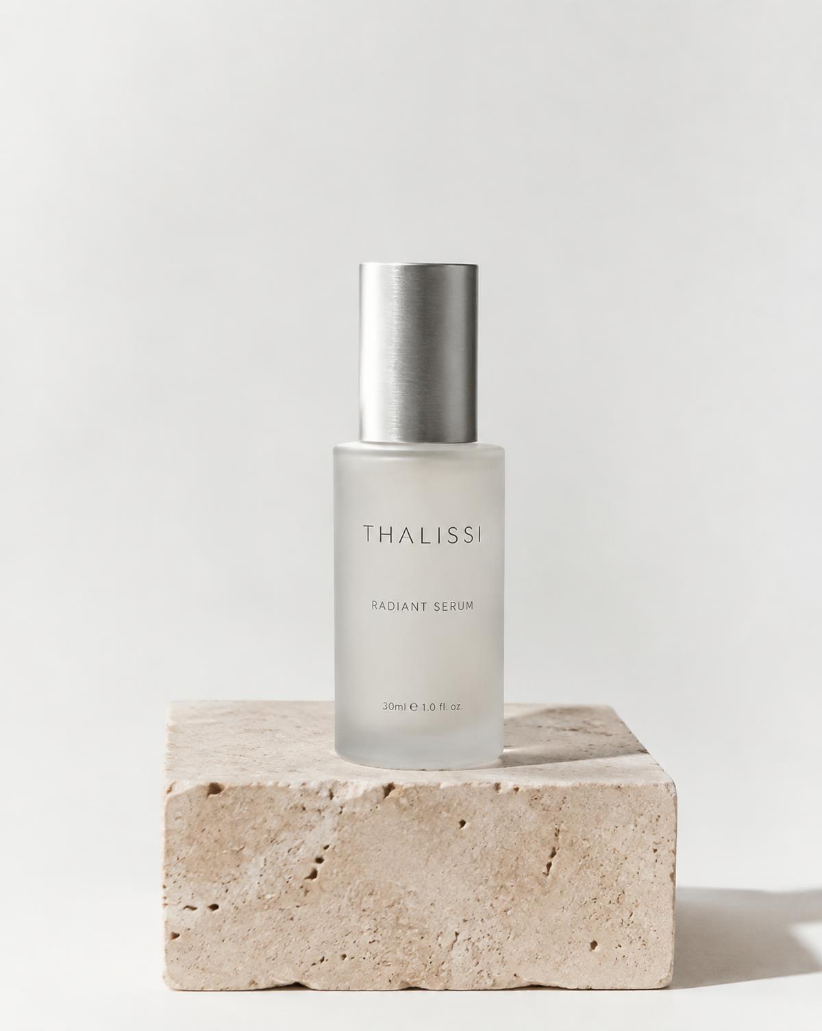 Frosted glass serum bottle on travertine